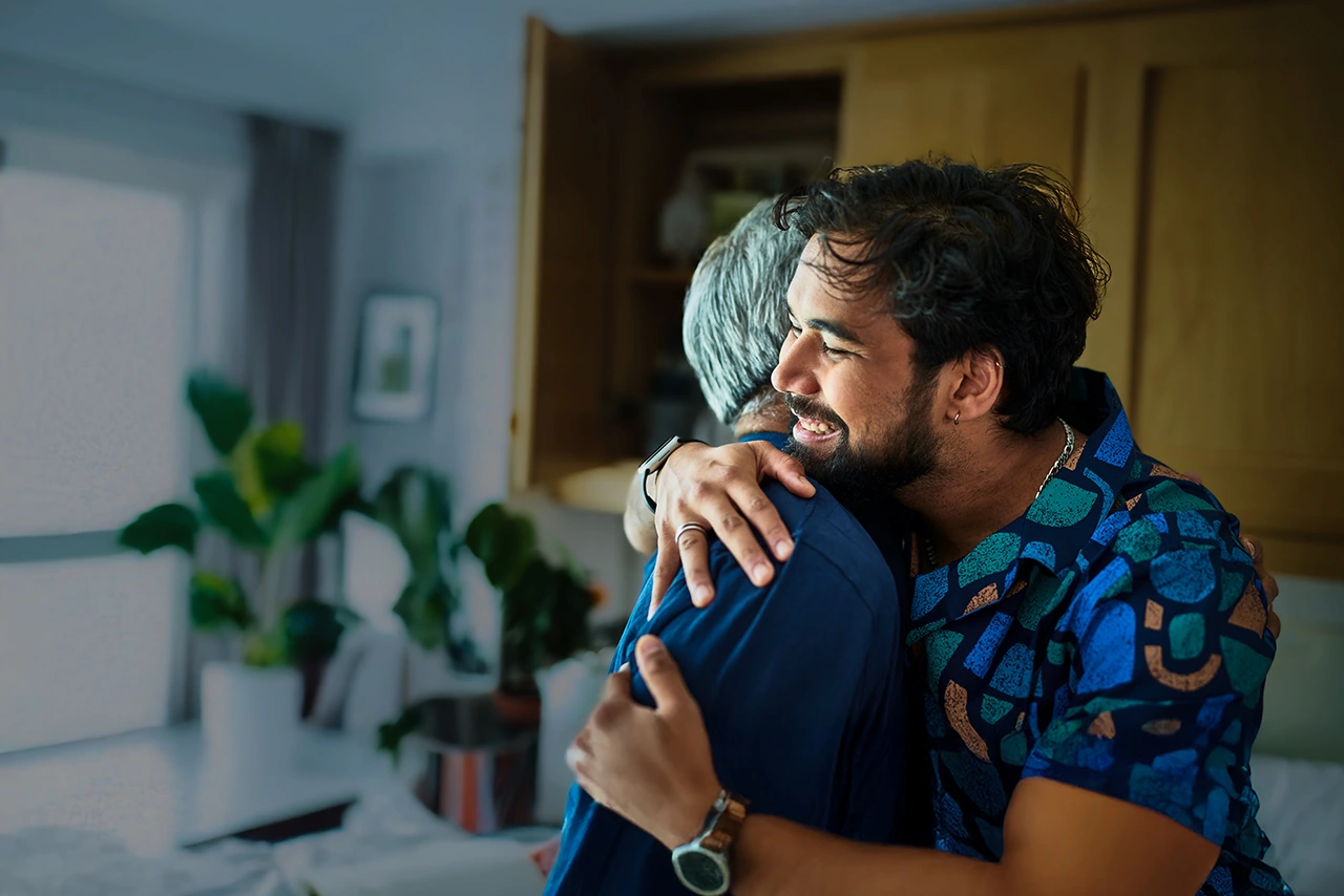 A father and older son of hispanic decent embrace